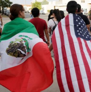 One person wearing a Mexican flag stands next to another wearing an American flag at a rally against hate on June 4 in the wake of a mass shooting which killed 21 at a Wal-Mart store in El Paso, Texas.